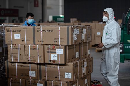 2020年2月4日，工作人員和志願者在武漢的一個倉庫轉送醫療用品。（STR/AFP via Getty Images）