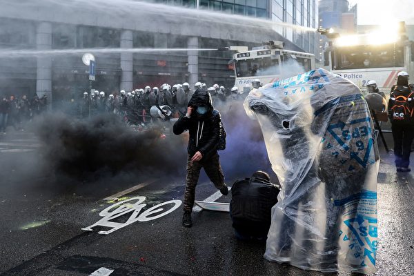 2021年12月5日，比利時布魯塞爾，民眾不滿政府的COVID-19防疫政策，聚集到街上抗議。警方出動水炮車，試圖驅散抗議民眾。（Kenzo Tribouillard/AFP via Getty Images）