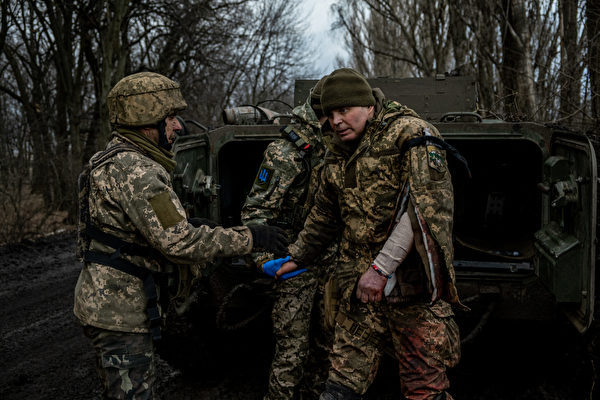 2023年3月8日，巴赫穆特（Bakhmut）附近，在俄烏戰爭期間，烏克蘭醫務兵協助一名受傷的烏克蘭士兵撤離。（Sergey Shestak/AFP）