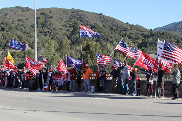 12月19日，在洛斯阿圖斯（Los Gatos）參加集會的民眾，站在路邊，高舉美國國旗等旗幟，向過往車輛揮舞，聲援特朗普，反對竊選。（大紀元）