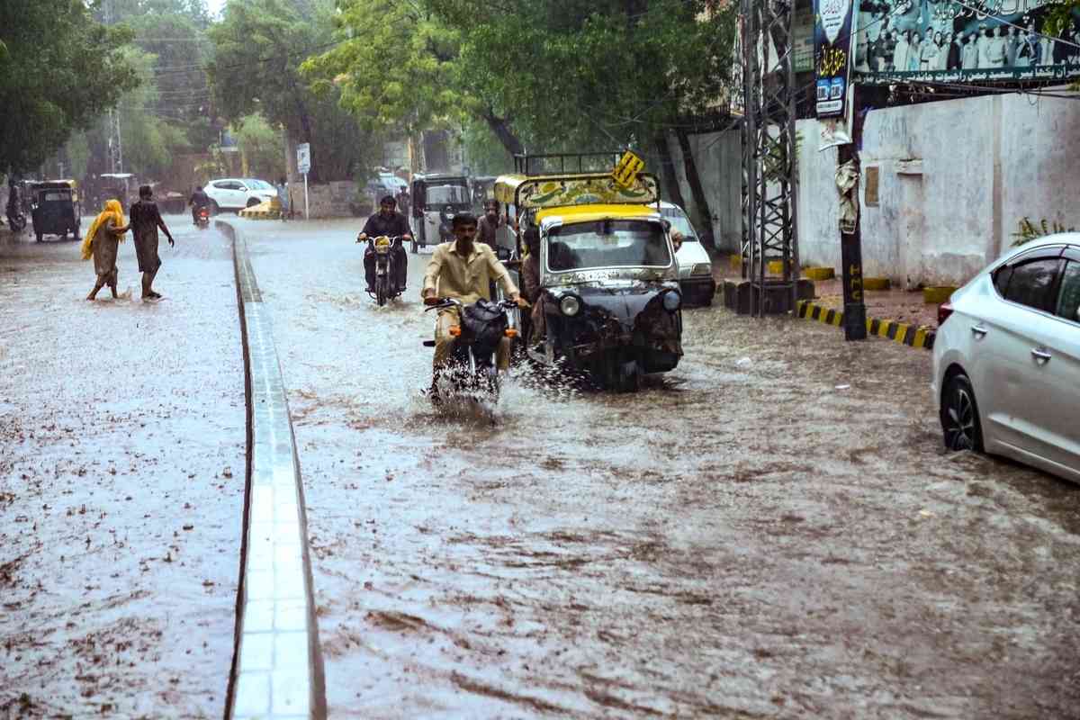 2025年7月14日,巴基斯坦信德省海得拉巴市(Hyderabad)遭暴雨襲擊後,民眾被迫涉水出行。(Jan Ali Laghari/Middle East Images/AFP via Getty Images)