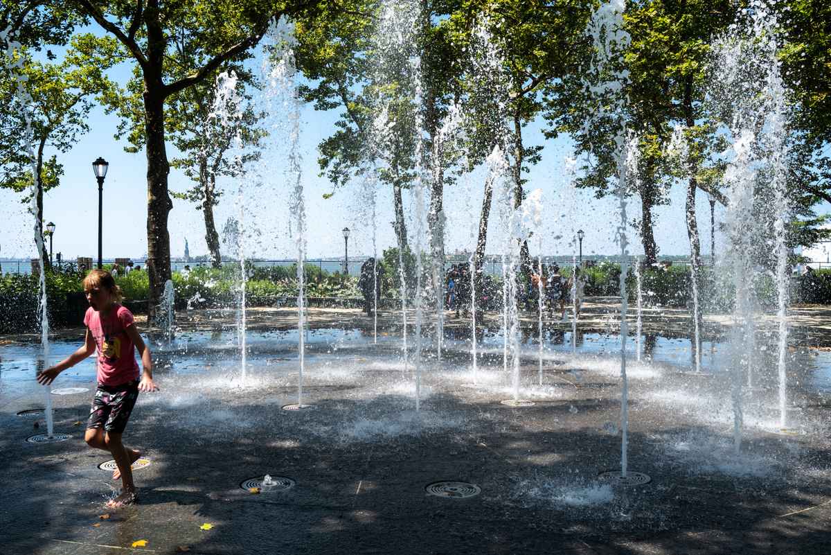 2022年7月19日，高溫下，一個孩子在紐約市曼哈頓的一處公園噴泉玩水。熱浪席捲紐約市和東海岸大部份地區，氣溫達90℉至100℉的高溫。（Spencer Platt/Getty Images）