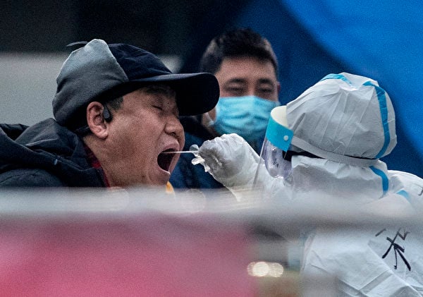 1月23日，在北京東城區進行大排查，穿著防護服的衛生人員給居民作核酸檢測。（Kevin Frayer/Getty Images）