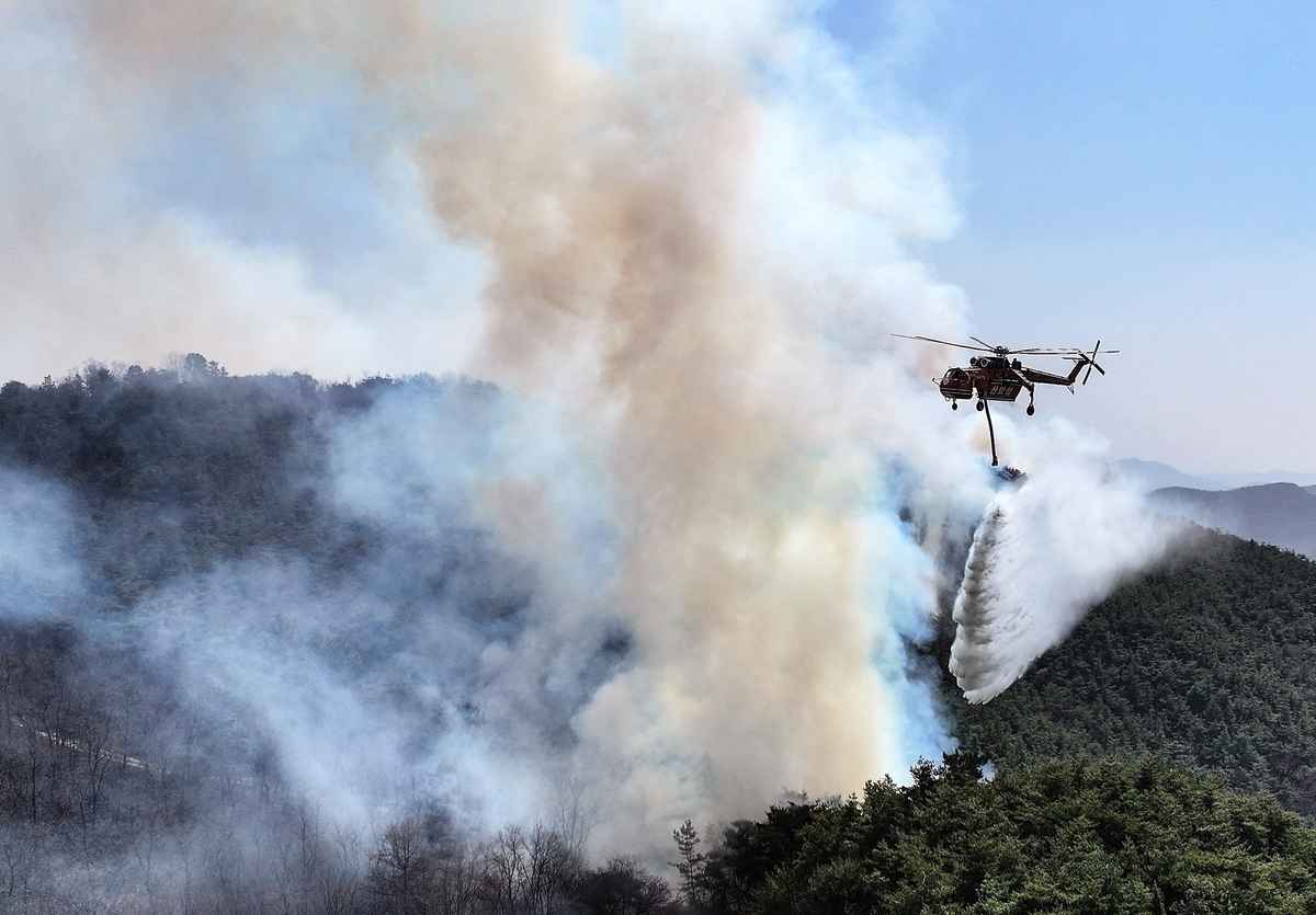 2025年3月23日,一架直升機在慶尚北道義城郡(Uiseong County)起火點附近協助撲滅大火。(YONHAP/AFP)