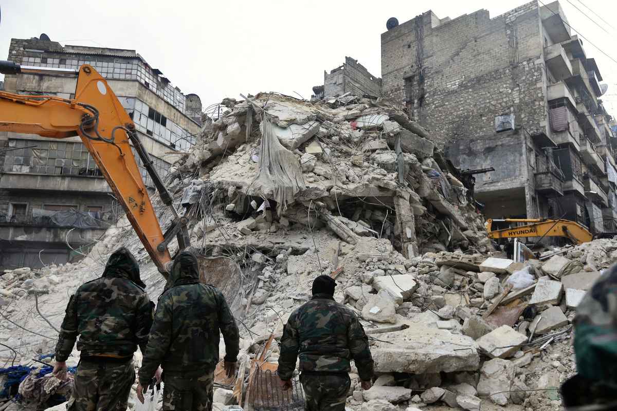 2023年2月6日，阿勒頗市（Aleppo）發生致命地震後，敘利亞救援隊在倒塌的建築廢墟中搜尋受害者和倖存者。當天，鄰國土耳其發生7.8級地震，兩國有數千人死亡。（Louai Beshara/AFP via Getty Images）