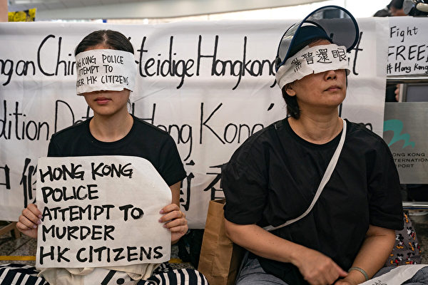 8.11一位少女被射穿右眼，8月12日港人在機場矇眼抗議。（Anthony Kwan/Getty Images）