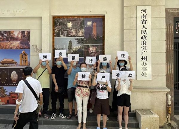 部份居住在廣州的民眾前往河南省駐廣州辦事處舉牌，要求「河南村鎮銀行償還儲戶存款」。（網絡圖片）