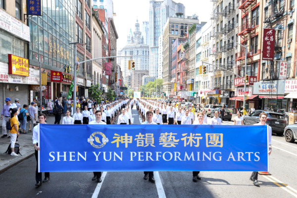 2025年7月20日,神韻部份藝術家參加在曼哈頓華埠舉行的盛大反迫害遊行,舉著寫有「神韻藝術團」的橫額。(Benny Zhang/The Epoch Times)