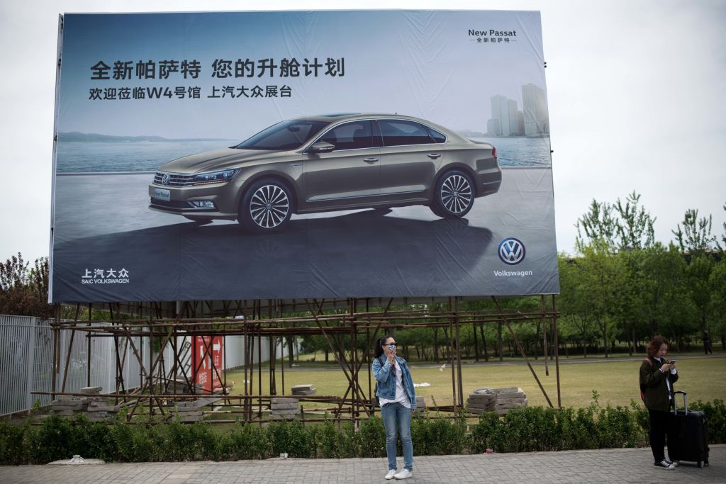 福士汽車是最早進入中國的德國車商之一。圖為路人站在北京福士汽車的一個廣告牌下。（NICOLAS ASFOURI/AFP via Getty Images）