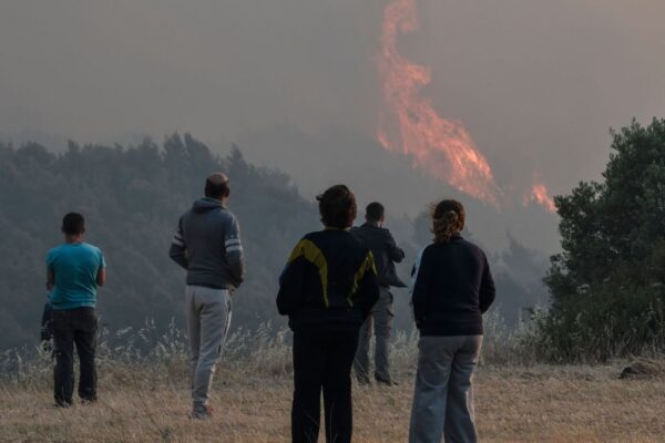 2021年5月20日，當地居民在雅典西部的Pefkaneas村附近查看森林火災。（LOUISA GOULIAMAKI/AFP via Getty Images）