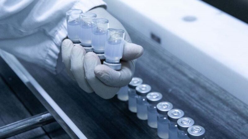 2021年4月23日，中國科興疫苗生產線上的工作人員，在工作時展示已灌入了疫苗的瓶子。（Alexandre Schneider/Getty Images）