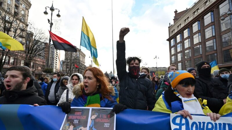 2022年2月12日，在基輔舉行的集會上，示威者在一面寫有 "烏克蘭人將進行抵抗 "的國旗顏色的橫幅後面高喊口號。（SERGEI SUPINSKY/AFP via Getty Images）