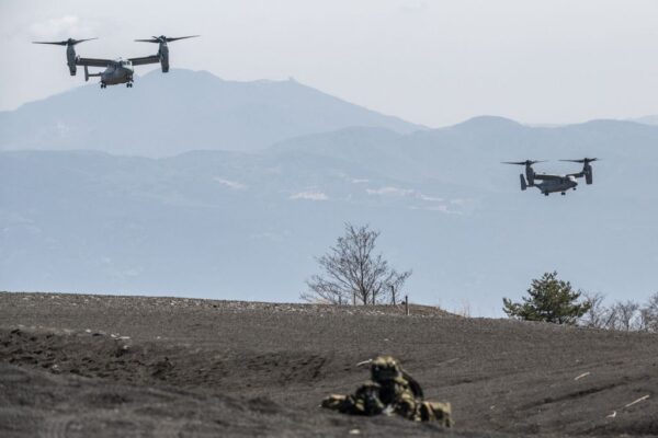 圖為，2022年3月15日，日本自衛隊一名成員在靜岡縣御殿場的東富士訓練區與美國海軍陸戰隊人員舉行聯合演習中堅守崗位，同時美國海軍陸戰隊的MV-22「魚鷹」戰機降落。（CHARLY TRIBALLEAU/AFP via Getty Images）
