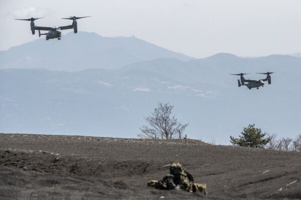 圖為,2022年3月15日,日本自衛隊一名成員在靜岡縣御殿場的東富士訓練區與美國海軍陸戰隊人員舉行聯合演習中堅守崗位,同時美國海軍陸戰隊的MV-22「魚鷹」戰機降落。(CHARLY TRIBALLEAU/AFP via Getty Images)
