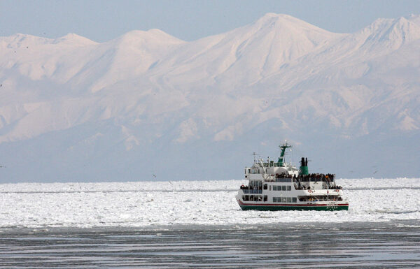 2007年2月10日，一艘船在鄂霍次克海的流冰中航行，背景是知床半島的山脈。知床半島於2005年7月被世界遺產委員會列入了世界自然遺產名錄。（TOSHIFUMI KITAMURA/AFP via Getty Images）