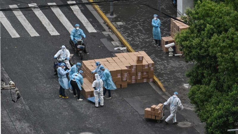 2022年5月13日，上海防疫人員在搬運物資。（HECTOR RETAMAL/AFP via Getty Images）