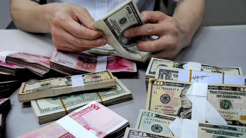 資料圖。中國江蘇省連雲港市的中國銀行分行一位工作人員正在清點美元和人民幣現鈔。（ VCG/VCG via Getty Images）