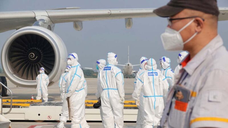 2022年9月18日，中國山東省煙台機場，航空地勤人員在一架從國外飛來的飛機上工作時，都穿著全套個人防護裝備。（STR/AFP via Getty Images）