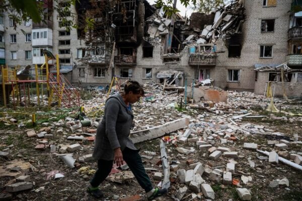 2022年9月30日，在俄羅斯入侵烏克蘭的情況下，一名行人在頓涅茨克州斯維亞托希爾斯克鎮一棟被毀的公寓樓院子裏行走。 （ANATOLII STEPANOV/AFP via Getty Images）