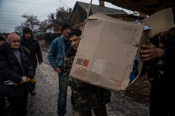 圖為2022年12月8日，烏克蘭頓涅茨克地區巴赫穆特市的居民獲得了一箱人道主義援助物資。（IHOR TKACHOV/AFP via Getty Images）