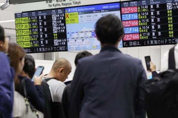 2023年6月2日，乘客在新大阪站的新幹線檢票口，查看有關列車的時刻表。（STR/JI Press/AFP via Getty Images）