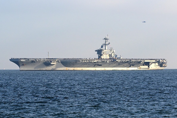 2024年11月22日,喬治華盛頓號核動力航空母艦駛入東京灣,前往位於東京以南神奈川縣橫須賀的美國海軍基地,船員在甲板上一字排開。(STR/JIJI Press/AFP via Getty Images)