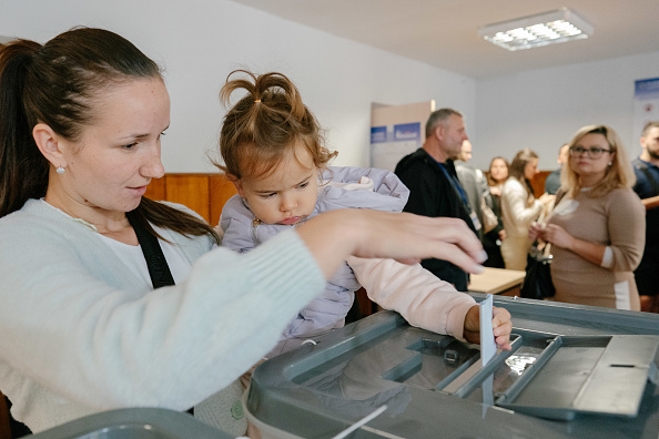 2025年9月28日,一名婦女在基希納烏的投票站內投下選票。(Andrei Pungovschi/Getty Images)