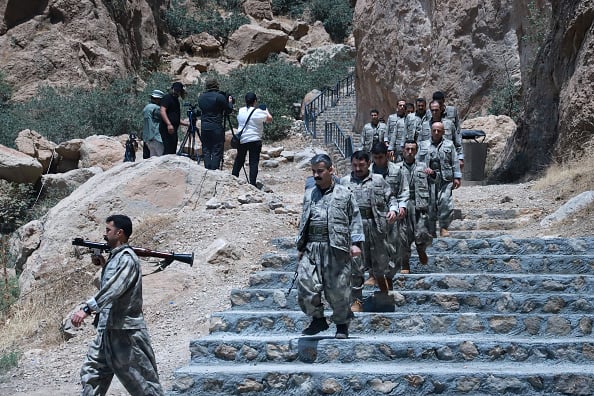 2025年7月11日,在伊拉克庫德斯坦自治區蘇萊曼尼亞,庫德工人黨(PKK)戰士在儀式前走下樓梯。(SHWAN MOHAMMED/AFP via Getty Images)