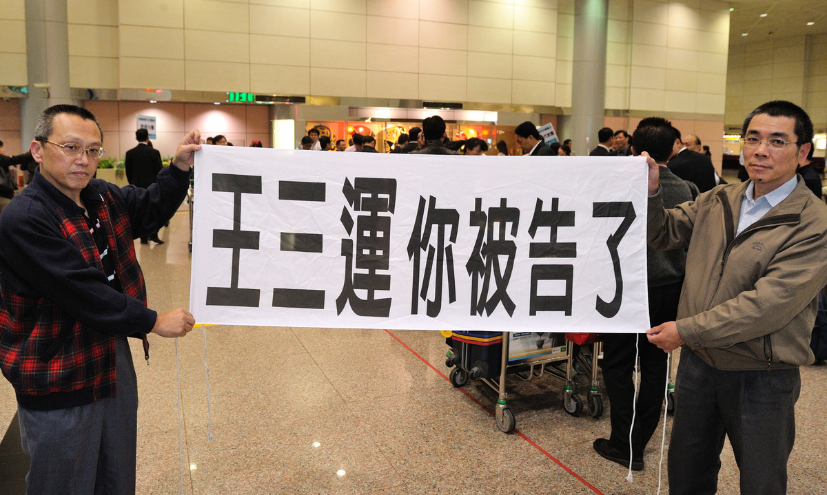 王三運2011年4月來台，法輪功學員在機場中拉橫幅。（大紀元）